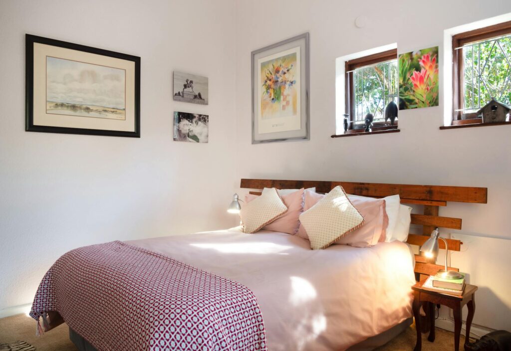 A warm and inviting bedroom featuring decorative art and natural light.